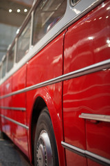 Part of red retro bus with passenger seats.