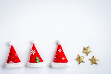 Weihnachtsmützen und goldene Sterne auf weiß
