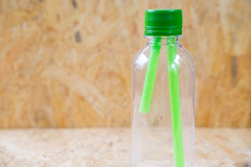 Green straws inside a transparent bottle