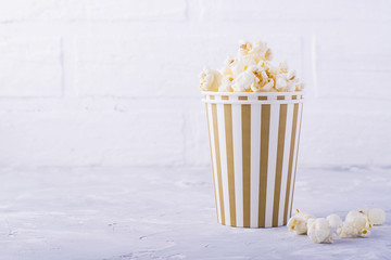 Popcorn in paper cup on white background.