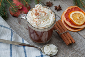 Christmas cocoa with whipped cream, chocolate, walnuts, cinnamon