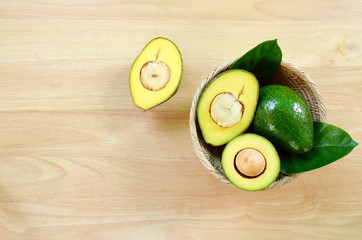 Fresh avocado fruits on a wood background.