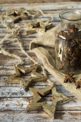 Garland of the Christmas star, a jar of anise on a wooden old table. Rustic style.