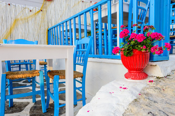 Traditional Greek restaurant on the open air with bright blue chairs and flowers, Kos town,...