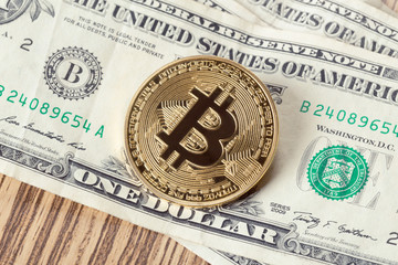 Golden bitcoin coin and one dollar banknote
