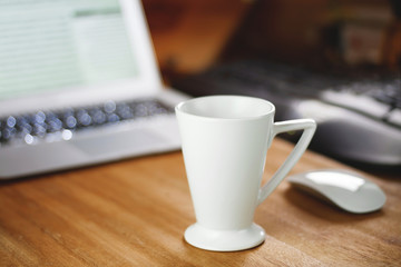 White cup on the desktop.