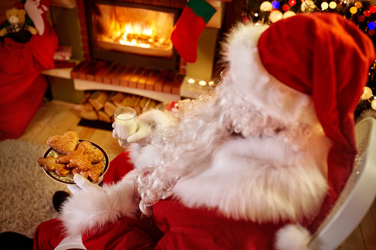 Santa Claus relaxing at home with milk and fresh cookies