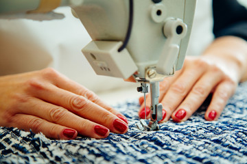 Women's hands at work with sewing machine