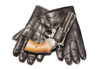Mafia concept. Black gun on leather gloves isolated