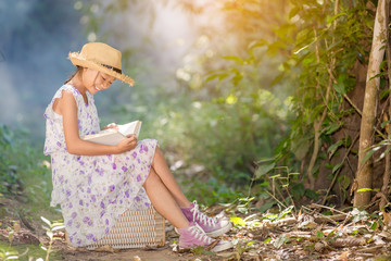 asian girl reading book in the forest