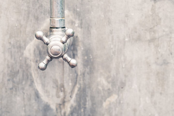 Fototapeta na wymiar Water tap on concrete wall, outdoor rain shower