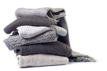 Stack of various sweaters isolated on white background