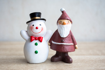 Santa claus and snowman with vintage filter, On wooden table.
