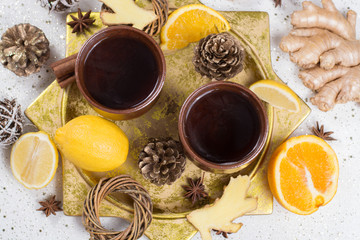 Two clay mugs with christmas winter tea with ginger, anise, sugar, honey