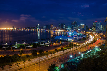 Fototapeta na wymiar Skyline of large African city Luanda and its seaside during the blue hour with many lights