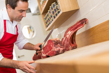 Butcher Cutting Meat At Counter