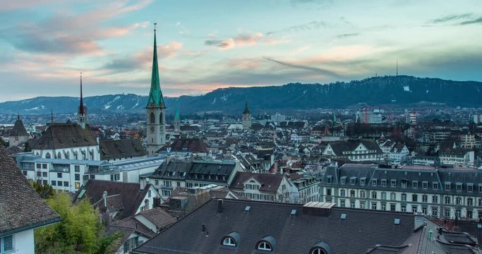 Zurich, Switzerland - view over the roofs of Zurich with church Fraumuenster from Polyterrace of ETH Zurich at sunset - Timelapse with zoom out