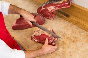 Butcher Cutting Meat At Counter high angle