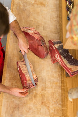 Butcher Cutting Meat At Counter high angle