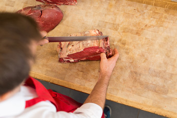 Butcher Cutting Meat At Counter high angle