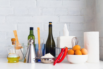 Cooking concept - salt, eggs, wine, oil, vinegar, flour, paper napkins, towel. Piece of kitchen interior..