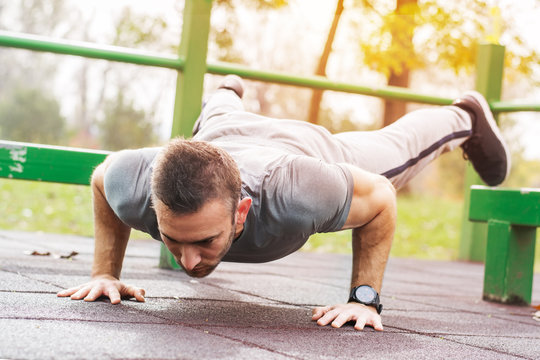 Push-ups - fitness man training push up outside.