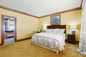 Master bedroom in pastel yellow tones with queen size bed