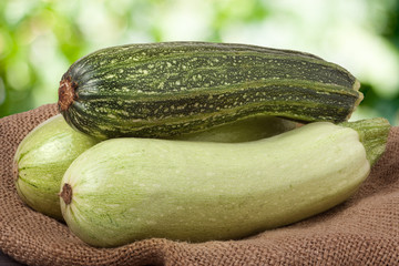 green zucchini and courgettes on sackcloth with a blurred background
