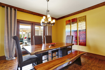 Dining room interior. Rustic wooden table, bench and high-back chairs.