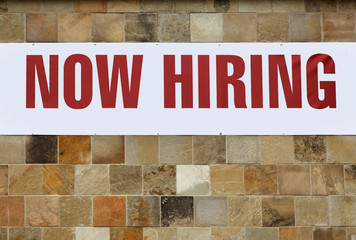 NOW HIRING Sign Attached to Tile Wall