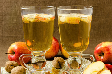 Hot apple cider with apples and slices in cups