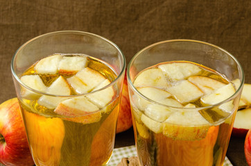 Hot apple cider with apples and slices in cups