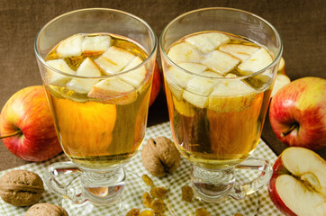 Hot apple cider with apples and slices in cups