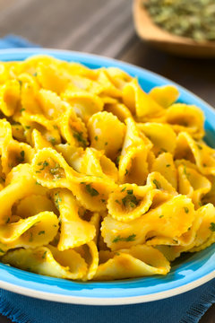 Pasta with pumpkin and parsley sauce served on plate, photographed with natural light (Selective Focus, Focus one third into the dish)