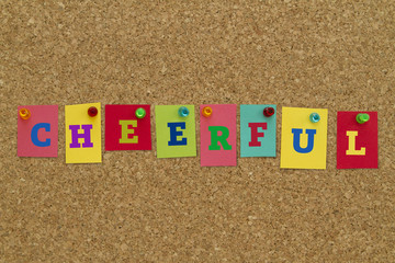 Cheerful word written on colorful sticky notes pinned on cork board.