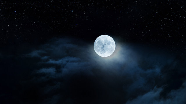 Luna gigante fra le nubi e il cielo stellato