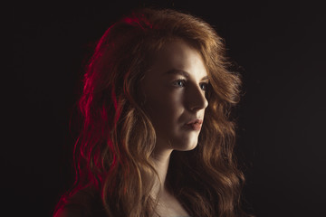 Fototapeta premium Luxurious woman with shadow on her face and red light