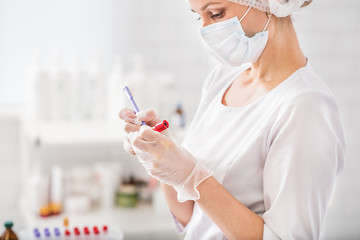 Medical specialist working with blood test-tubes