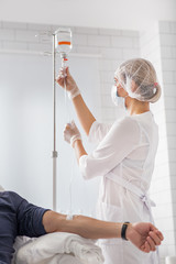 Female physician preparing dropper for man