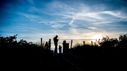 Silhouettes of a family on a hike at sunset - 126866424