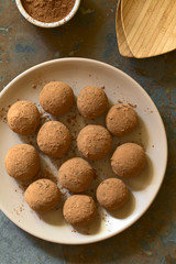 Rum balls covered with cocoa powder, photographed overhead on slate with natural light (Selective Focus, Focus on the top of the balls)