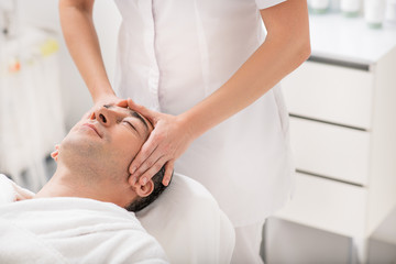 Obraz na płótnie Canvas Businessman relaxing during massage at spa