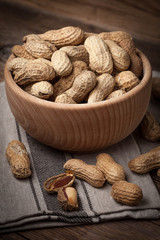 Dried peanuts in wooden bowl.