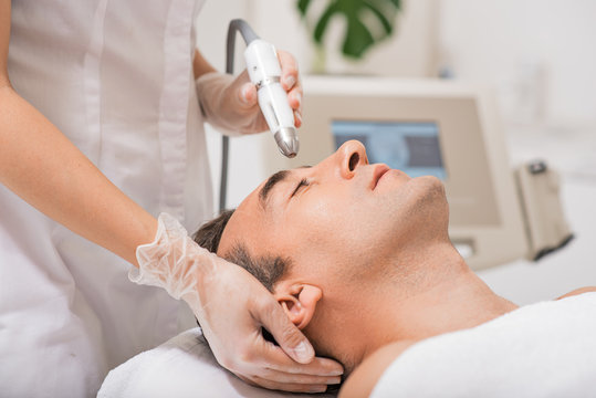 Beautician doing ultrasound cavitation facial massage