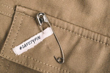Safety pins on clothes with label "I am a safe place" as a symbol of solidarity
