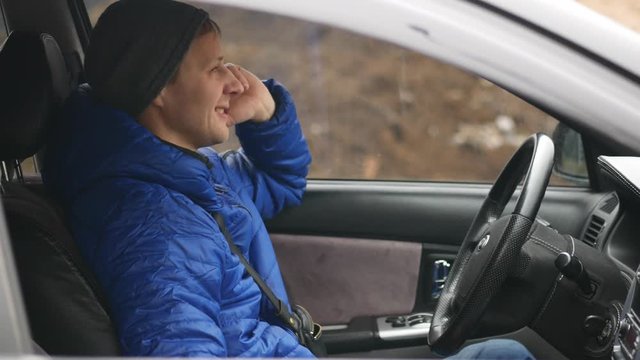 A Man Siting In The Car And Speaking On Mobile Phone