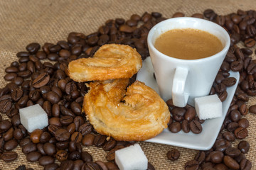 Cup and grain of coffee over textile background
