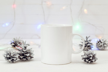 White coffee mug with Christmas cones and burning garland. Space