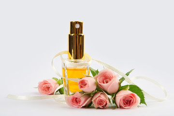 Perfume bottle with flowers on light background