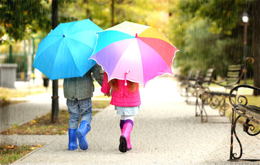 Cute children with umbrellas in park